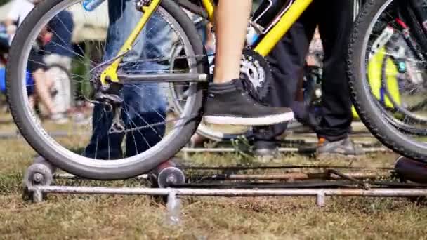 Close-up, de wielen van een oude hometrainer, de fiets rijdt op één plaats met behulp van een speciale zelf-gemaakte meubilair, installatie. — Stockvideo
