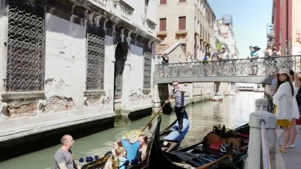 VENECIA, ITALIA - 7 DE JULIO DE 2018: canal estrecho entre las antiguas casas de Venzia, caluroso día de verano. góndola veneciana tradicional flota a lo largo del canal, lleva a los turistas — Vídeo de stock