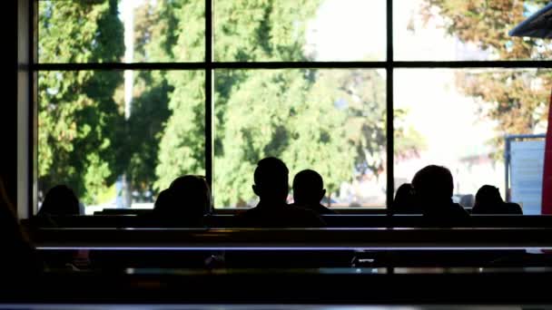 Cafetería, cafetería, establecimiento de catering. muchas siluetas oscuras de las personas en el fondo de una gran ventana. personas almorzando dentro de un restaurante moderno con grandes ventanales — Vídeos de Stock