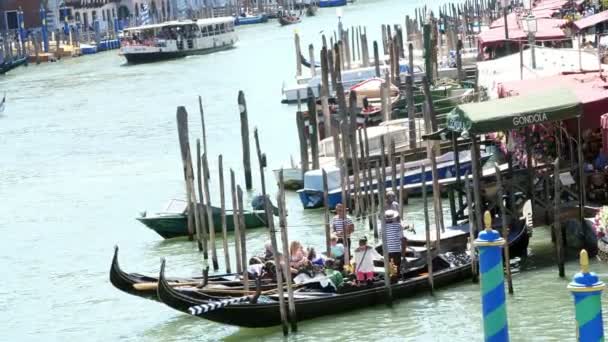 VENICE, ITALY - JULY 7, 2018: gondoliers are waiting for tourists on special piers, stops for gondolas. Grand Canal , hot summer day. — Stock Video