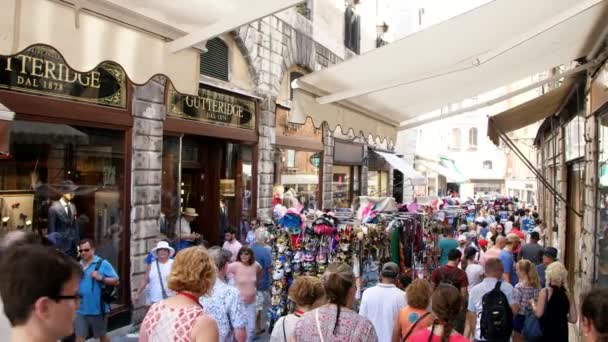 VENECIA, ITALIA - 7 DE JULIO DE 2018: calles comerciales de Venecia, muchas tiendas, tiendas de recuerdos. Los turistas están comprando recuerdos. caliente día de verano . — Vídeos de Stock