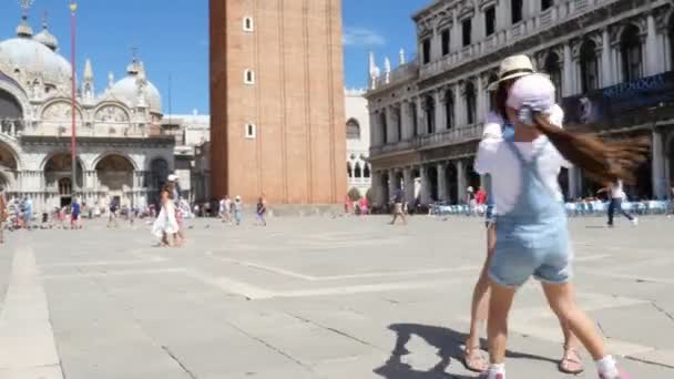 意大利威尼斯-2018年7月7日: 快乐美丽的女人和女孩的看法, 游客, 牵手, 在圣马可广场上旋转, 在圣马克大教堂, 在一个夏天的一天 — 图库视频影像