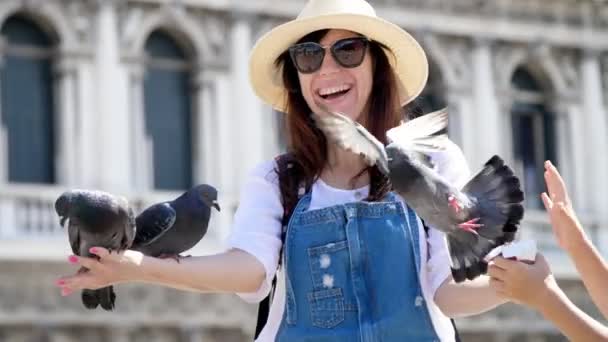Venedig, Italien - 7 juli 2018: porträtt av glad kvinna, turist, hålla duvor, utfodring, leka med dem, ha kul på Piazza San Marco, St Marks Basilica, en sommardag — Stockvideo