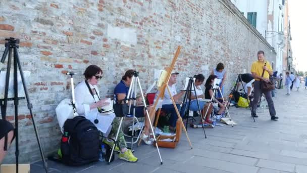 ВЕНИЦИЯ, ИТАЛИЯ - 7 ИЮЛЯ 2018 года: на пирсе Венеции многие художники, взрослая группа, студенты художественной школы проводят урок рисования, рисования морской накидки. летний жаркий день . — стоковое видео