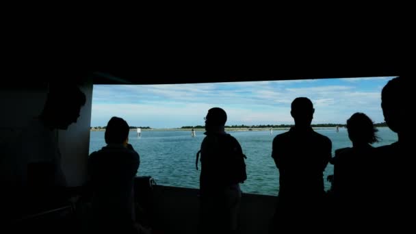 Venice, Italië - 7 juli 2018: donkere, zwarte contouren, silhouetten van mensen tegen de achtergrond van een bewegende zeegezicht. mensen zweven op de boot, vaparetto. hete zomerdag. — Stockvideo