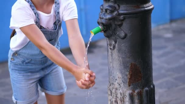 VENISE, BURANO, ITALIE - 7 JUILLET 2018 : l'eau cristalline coule d'une vieille fontaine de fer publique, un puits, gamine se lave les mains sous un ruisseau d'eau. gros plan — Video