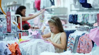 mağazada alışveriş. Çocuk giyim bölümünde. Kız, çocuğu, şeyler deposundaki seçer. Moda kız. küçük Alışverişkoliğin. sıkıcı mağazalarda alışveriş, Otelde Mağazalar Mevcut