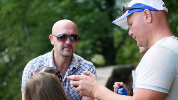 A man is holding a remote control drone, a small video helicopter. everyone looks on a small screen radio control with curiosity , man shoots video with a drone. — Stock Video