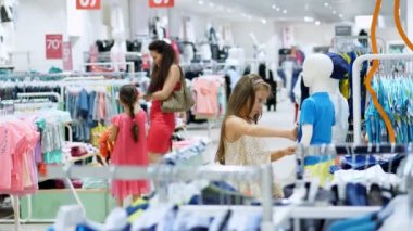 mağazada alışveriş. Çocuk giyim bölümünde. Kız, çocuğu, şeyler deposundaki seçer. Moda kız. küçük Alışverişkoliğin. sıkıcı mağazalarda alışveriş, Otelde Mağazalar Mevcut
