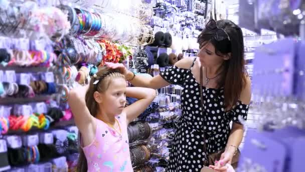 Womans hair accessories in shopping mall. girl, kid and mum choose  hairpins, rubber bands, hair band, in the store. — Stock Video ©  djtrenerstock #219697288