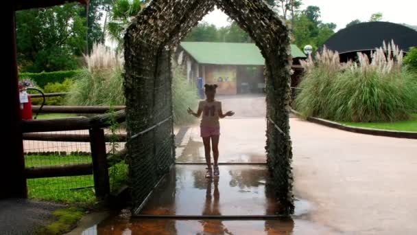 Safari Park Pombia, Itálie - 7 července 2018: zábava v zoo. Light air mrholení. voda se rozprašuje v malé chodbě, jehož prostřednictvím spuštění veselé děti. — Stock video