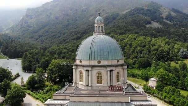 OROPA, BIELLA, ITALIA - 7 DE JULIO DE 2018: aero Vista del hermoso Santuario de Oropa, Fachada con cúpula del santuario de Oropa situado en las montañas cerca de la ciudad de Biella, Piamonte, Italia . — Vídeo de stock