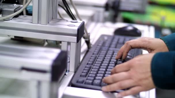 Un primer plano, las manos trabajan en el teclado. un trabajador en una empresa, una producción, en un taller, regula el funcionamiento de un proceso mecanizado a través de un ordenador . — Vídeos de Stock