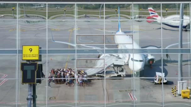 Flygplatsen Boryspil, Ukraina - 24 oktober 2018: Ukraina internationella flygbolag. passagerare ombordstigning planet och gör dig redo att flyg. speglar i speglade windows flygplatsen byggnaden. sommaren soligt — Stockvideo