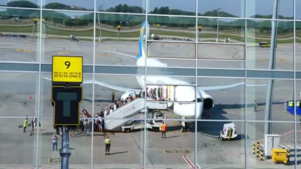 AÉROPORT BORYSPIL, UKRAINE - 24 OCTOBRE 2018 : Ukraine International Airlines. passagers Embarquez dans l'avion et préparez-vous au vol. reflet dans les fenêtres en miroir du bâtiment de l'aéroport. été ensoleillé — Video