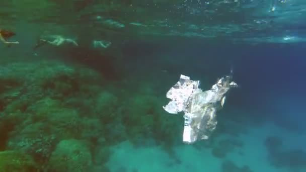 Primer plano de una bolsa de plástico flotando en el mar. Basura en el agua del mar. Contaminación ambiental de la contaminación por residuos plásticos en océanos y mares. Medio ambiente, concepto de contaminación — Vídeo de stock