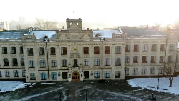 KIEV, KYIV, UCRANIA - 18 de noviembre de 2018: Vista aérea de un antiguo edificio de la Universidad Nacional Taras Shevchenko en Kiev, calle cubierta de nieve. día de invierno soleado . — Vídeos de Stock