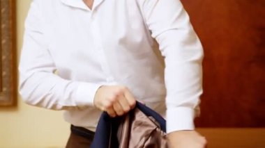 yakın, bir adam, bir ceket üzerine işadamı koyar önemli bir toplantı için hazırlar. damat düğün için giyiyor.