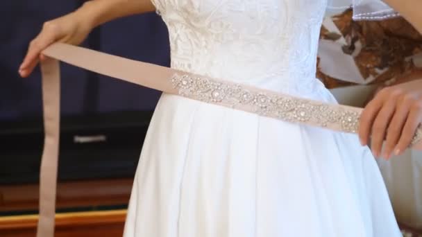 Honorarios de novia. La novia está vestida para la boda. primer plano de las manos de las novias con una manicura suave, sobre el fondo de un vestido de encaje blanco. Detalles del vestido de novia, de cerca . — Vídeos de Stock