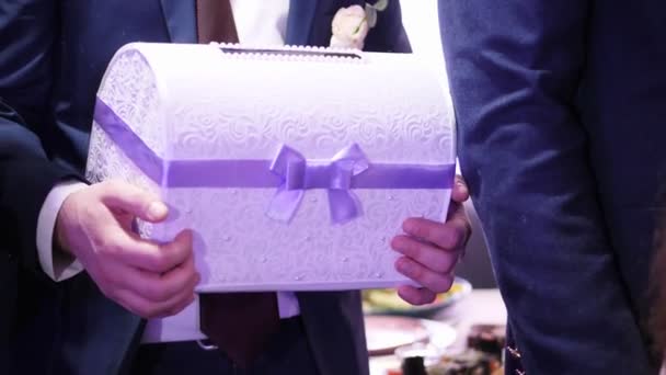 Primer plano, hermosa caja de encaje, con una cinta púrpura para regalos en efectivo, en una boda. accesorios de boda, tradiciones . — Vídeo de stock