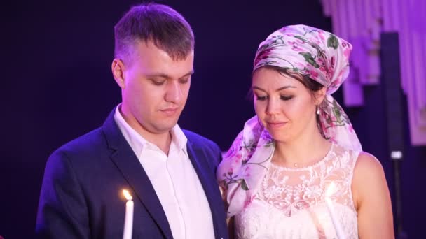 Tradiciones de boda, ceremonias. los recién casados están sosteniendo una vela blanca grande símbolo del hogar de la familia, la felicidad y el bienestar. padres encienden una vela de los recién casados con sus velas . — Vídeos de Stock