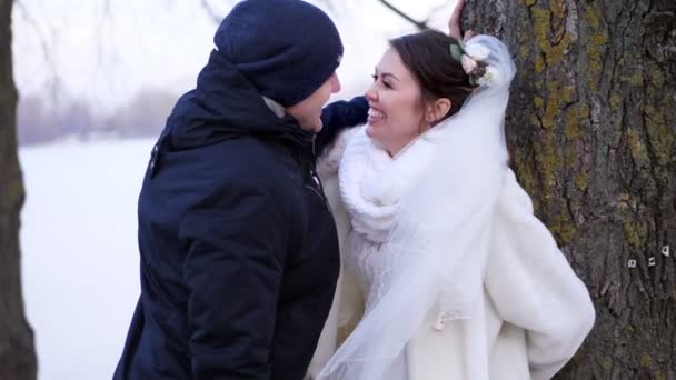 Zimní svatba, šťastný, smál se novomanželé hezky mluví. mrazivý, zasněžený den, na břehu řeky, na nábřeží ve městě. — Stock video