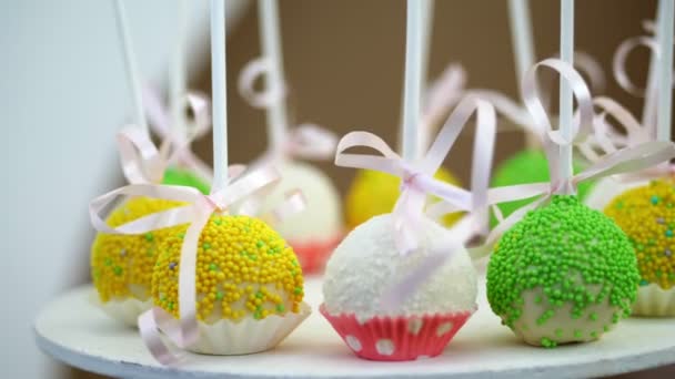 Dulces en el cumpleaños de los niños. primer plano, piruletas multicolores, dulces, galletas, cupcakes, decoración dulce para fiestas infantiles y aniversarios infantiles . — Vídeo de stock