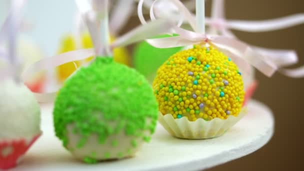 Dulces en el cumpleaños de los niños. primer plano, piruletas multicolores, dulces, galletas, cupcakes, decoración dulce para fiestas infantiles y aniversarios infantiles . — Vídeo de stock