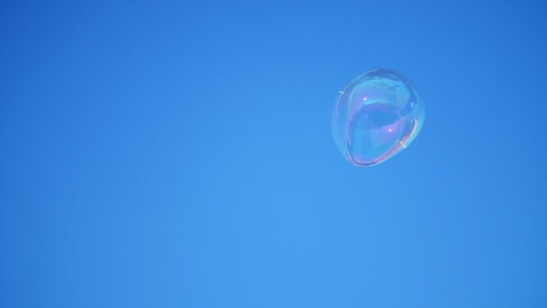 Close-up. a big soap bubble flies against the blue sky. — Stock Video