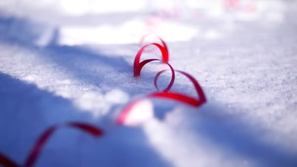 Close-up. on the snow are multi-colored tinsel and confetti. christmas decorations — Stock Video