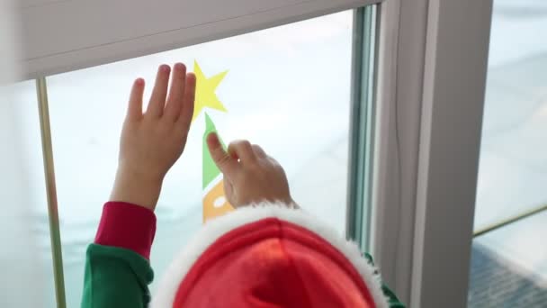 Primo piano, le persone decorano la finestra in casa con decorazioni natalizie, adesivi . — Video Stock