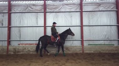 Özel hangarda bir Engelli genç bir siyah, safkan at, hippoterapi binmek öğrenir. adamın sağ ayağı yerine yapay bir kol var. Engelliler ile rehabilitasyonu kavramı