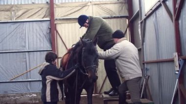Özel hangarda bir genç yakın gözetim öğretmenlerle bir ata binmek için yapay uzuv ile Engelli adam öğrenir onun atını bağlamaya yardımcı olurlar. hippoterapi. Engelliler ile rehabilitasyonu