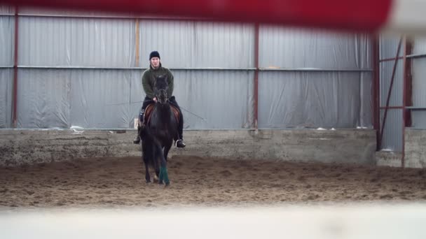 Özel hangarda bir Engelli genç bir siyah, safkan at, hippoterapi binmek öğrenir. adamın sağ ayağı yerine yapay bir kol var. Engelliler ile rehabilitasyonu kavramı