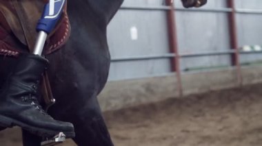 yakın çekim, yapay bacak, bacak stirrups içinde. Erkek binici, bacak, olmadan Engelli kişi ata, hippoterapi binmek öğrenir. hayvanlarla Engelli rehabilitasyonu kavramı.
