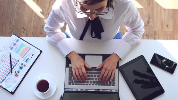 Überblick über zeitgenössische Geschäftsfrau, Analystin, Buchhalterin, die mit Dokumenten arbeitet, neues Geschäftsprojekt, am Laptop sitzend, Tastatur tippend. Arbeitsprozess im modernen Büro. — Stockvideo