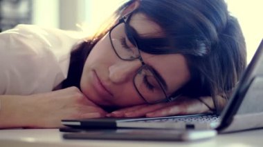 Overworked, Exhausted ve yorgun genç işkadını gözlüklü, dinlenme, Masa başında çalışma ofisinde bir dizüstü bilgisayar üzerinde uyuyor. o iş, portre vurdu boğulmuş olduğunu