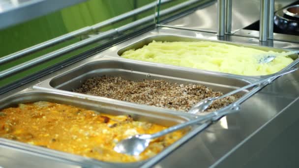 Detail, vitrína self servis restaurace s řadou nádobí, pohankové kaše, bramborová kaše, zeleninový guláš s omáčkou, omáčka — Stock video