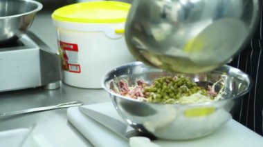 yakın çekim, metal bir kase salata kasesi mayonez sebze salatası yemek. aşçı tüm malzemeyi karışımları, birkaç kaşık mayonez ve biber koyar.