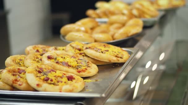 Detail, vitrína s mini pizza, kynutým těstem pečení v moderní jídelny, kavárny, samoobslužnou restauraci z veřejného stravování, jídelny — Stock video