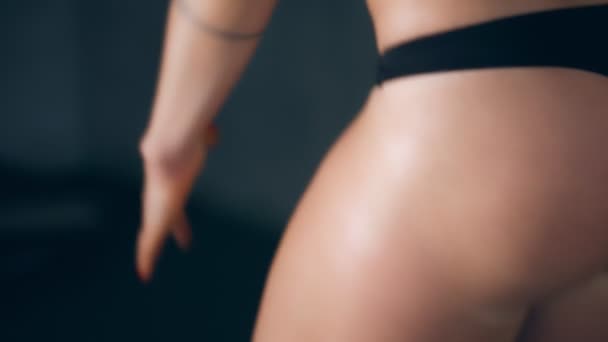 Close-up, une femme en string noir et haut de sport, fait, effectue des exercices. Le concept d'un corps beau, sportif, tonique et attrayant. jolie femme avec des hanches attrayantes, va dans le sport , — Video