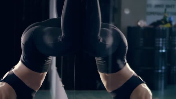 Närbild, kvinnlig rumpa, booty, höfter, i svarta leggings, flicka dansa twerk i studion. vacker figur, big booty kvinna på en svart spegel bakgrund i mörkret. Fitness, crossfit, dans, hälsa — Stockvideo