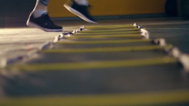 yakın çekim, kadın bacaklar siyah tayt ve spor ayakkabı. kadın çeviklik ladder kattaki spor salonunda bir atlet ayak merdiven, atlar, eğitim çalışmaları gerçekleştirir. Fitness sınıfı kardiyo egzersiz