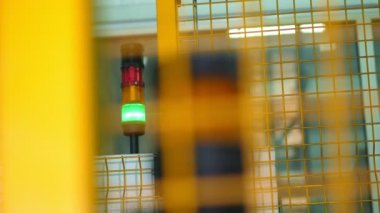 Closeup, fabrikada yeşil ve kırmızı elektrik ampulleri . uyarı işareti, fabrikada çit arkasında ekipman.