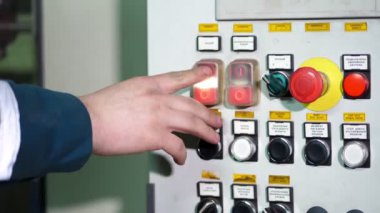 Üretim makinelerinde yanan ışıkların ve kontrol kadranlarının kapatılması. Bilgisayar kontrol makinesindeki düğmeler. Programlanabilir bir makinenin kontrol panelinde el.