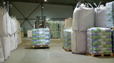 Ukrayna, Cherkasy, 25 Mart 2019: tarım şirketi Mais. Forklift sürücü istifleyici yükleyici ile mısır büyük paket paletleri istifleme, paletalır, büyük bir depodan taşır.