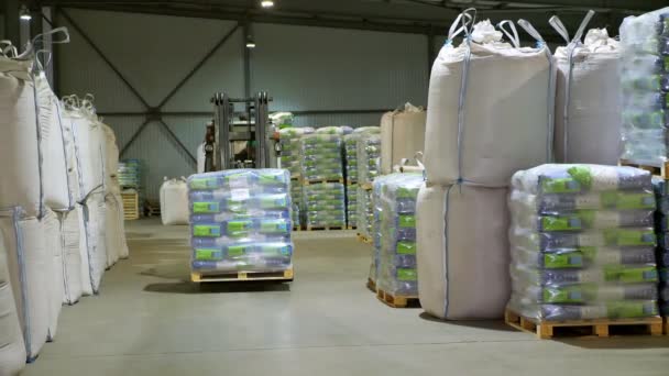Ukraina, Tjerkasy, mars 25, 2019: jordbruksföretag Mais. Gaffeltruck driver stapling Corn Large Pack pallar med staplare lastare, tar lastpallar bort, transporterar dem från ett stort lager. — Stockvideo