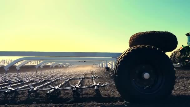 Close-up van kant naar cultivator, tractor op grote wielen ploegen, Eggen grond met grote metalen ploeg, verhoogt veel stof op akkerland, vruchtbare gebied van de boerderij. -bereidt de bodem voor inzaaien. Voorjaar — Stockvideo