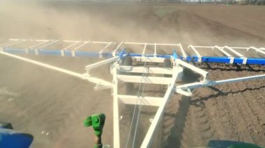 çiftliğin verimli tarlasına yetiştiricinin kabin görünümü. traktör pulluklar, büyük metal pulluk ile toprak harrows, ekilebilir arazi üzerinde toz bir sürü yükseltir - ekim için toprak hazırlar. Bahar