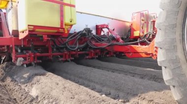 yakın çekim, mekanize makine patates dikim süreci. özel ekipman ile büyük traktör uzun düz üst sıralar yapar, oluklar, höyükler, yeni kara toprak alanında yeni dikilen patates için, bahar